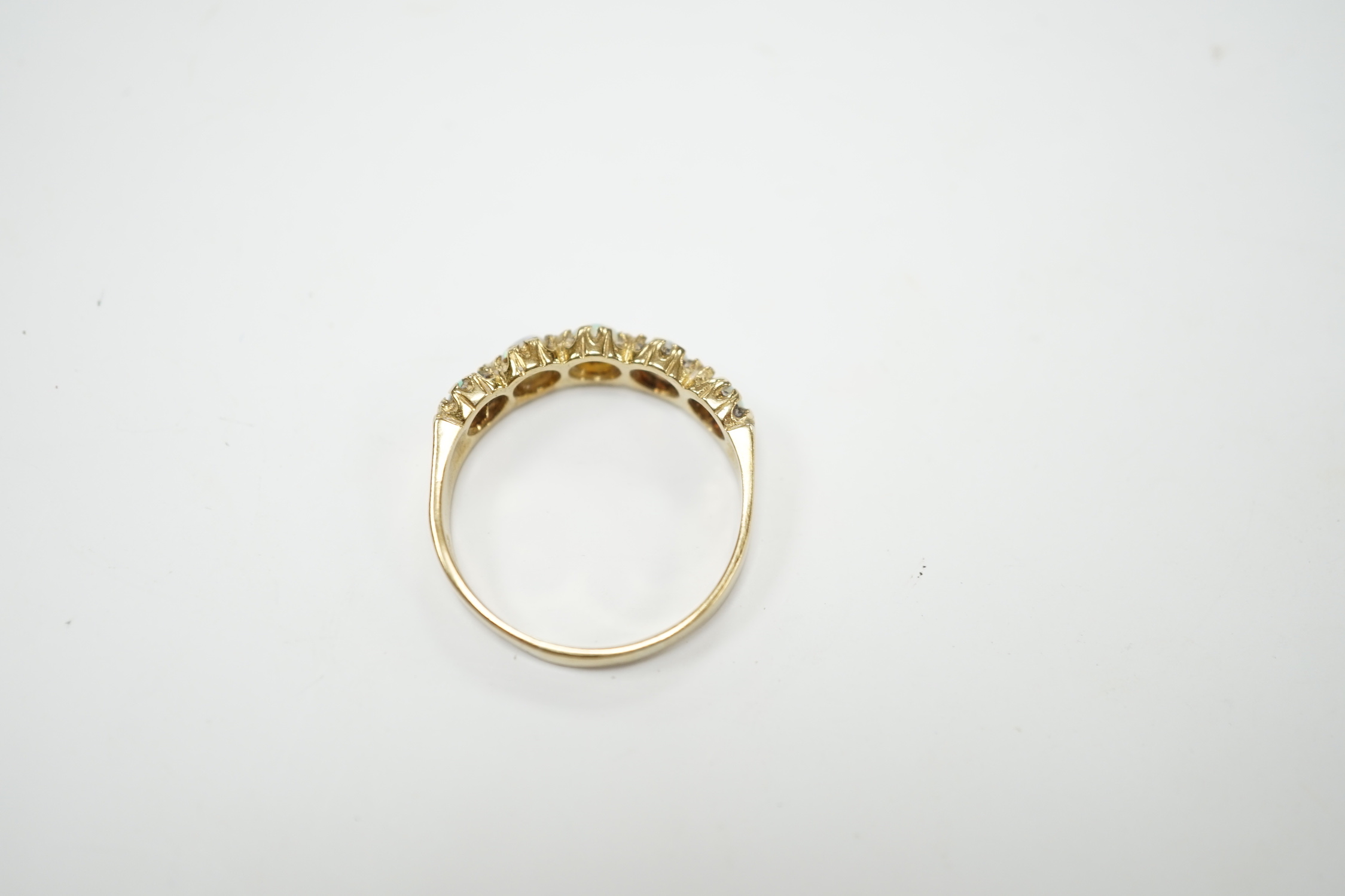 A modern 9ct gold and five stone white opal set half hoop ring, size T/U, gross weight 2.9 grams.